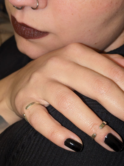 Model wearing torc ring with black nails and red lipstick