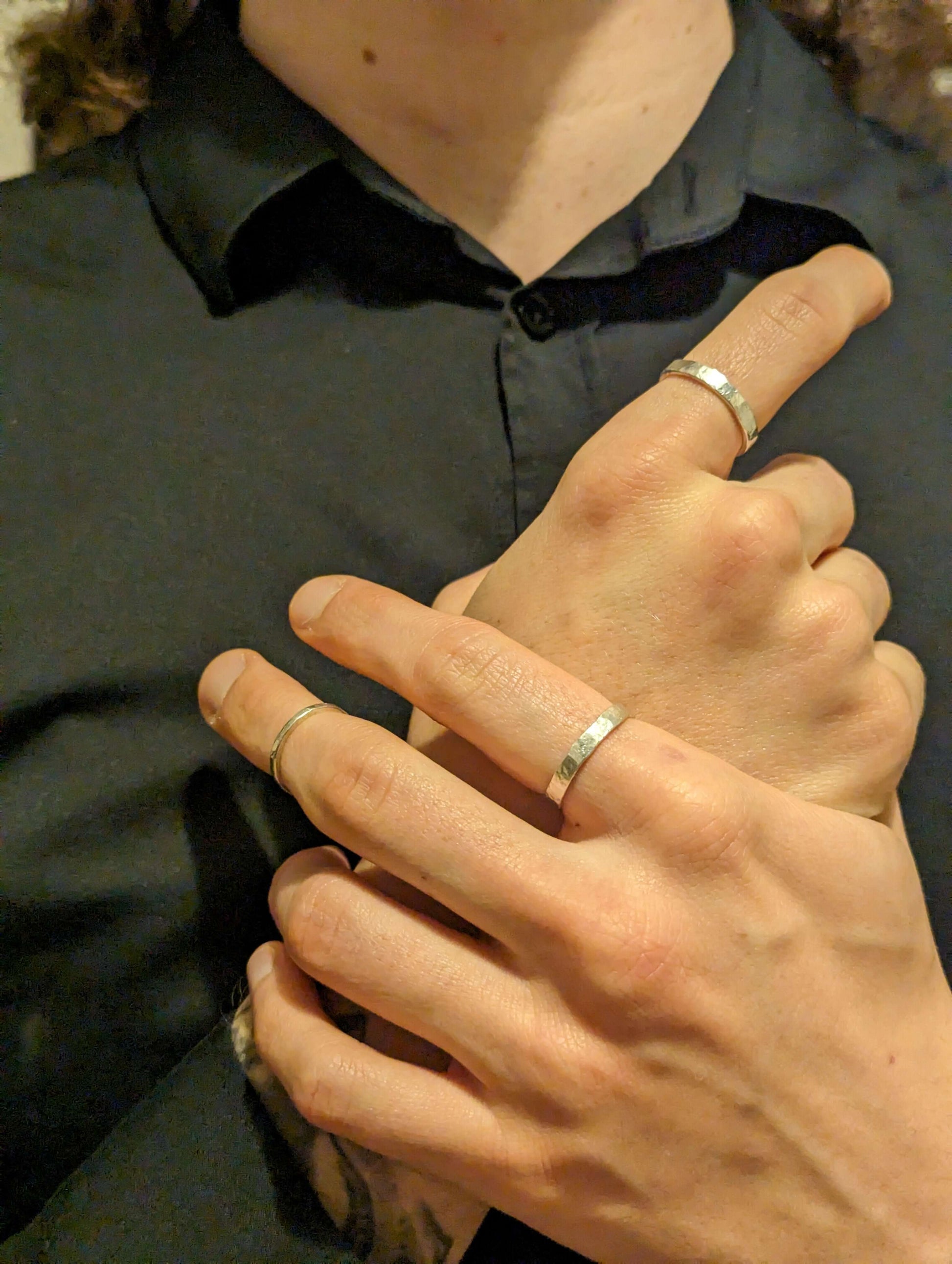 Model wearing two irregular wave silver rings with a black shirt