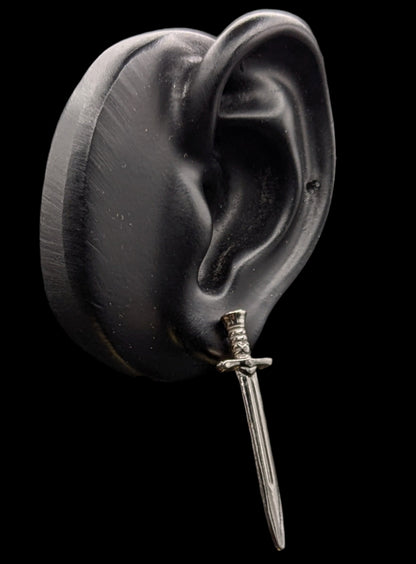 Silver dagger earring on a black background