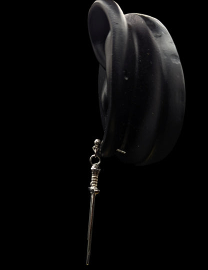Black hat with a decorative stickpin on a black background
