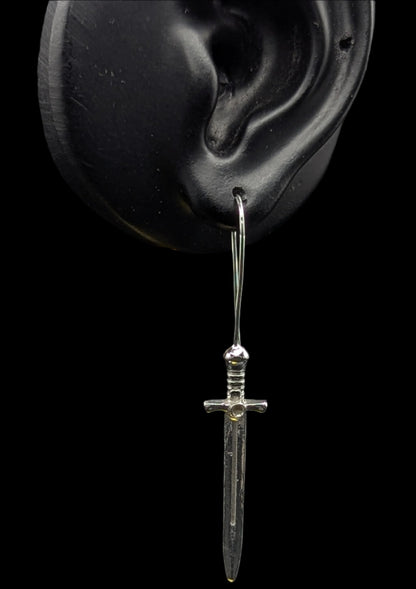Silver dagger-shaped earring on a black background