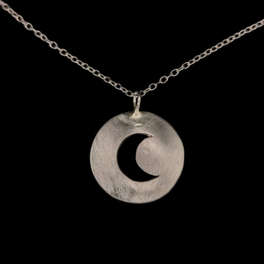 Silver necklace with a crescent moon pendant on a black background