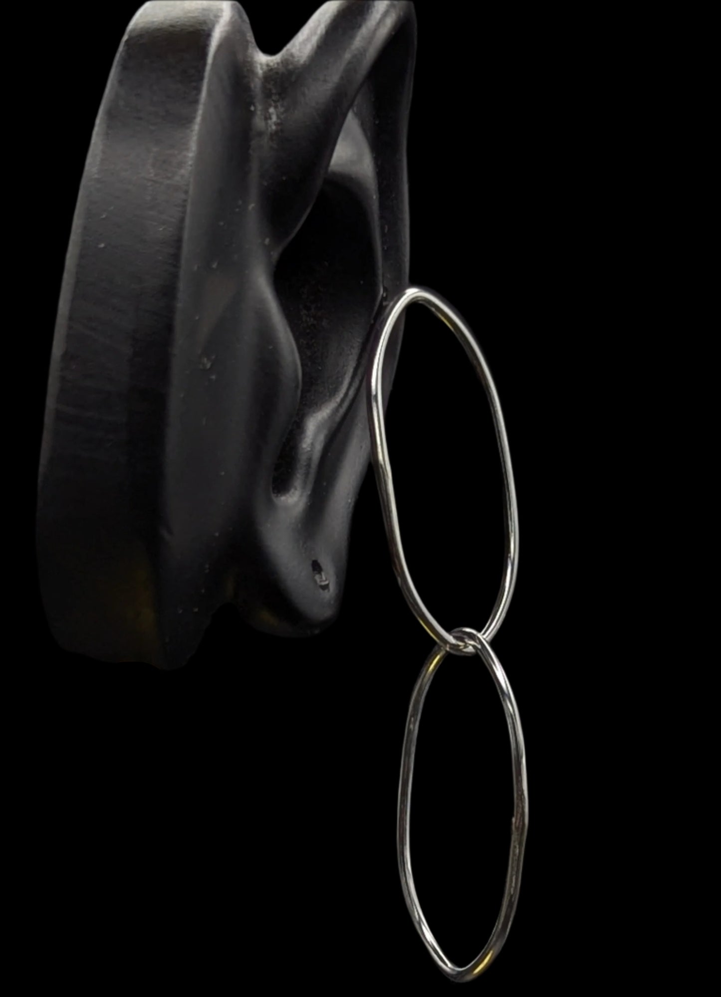 Silver hoop earrings on a black background