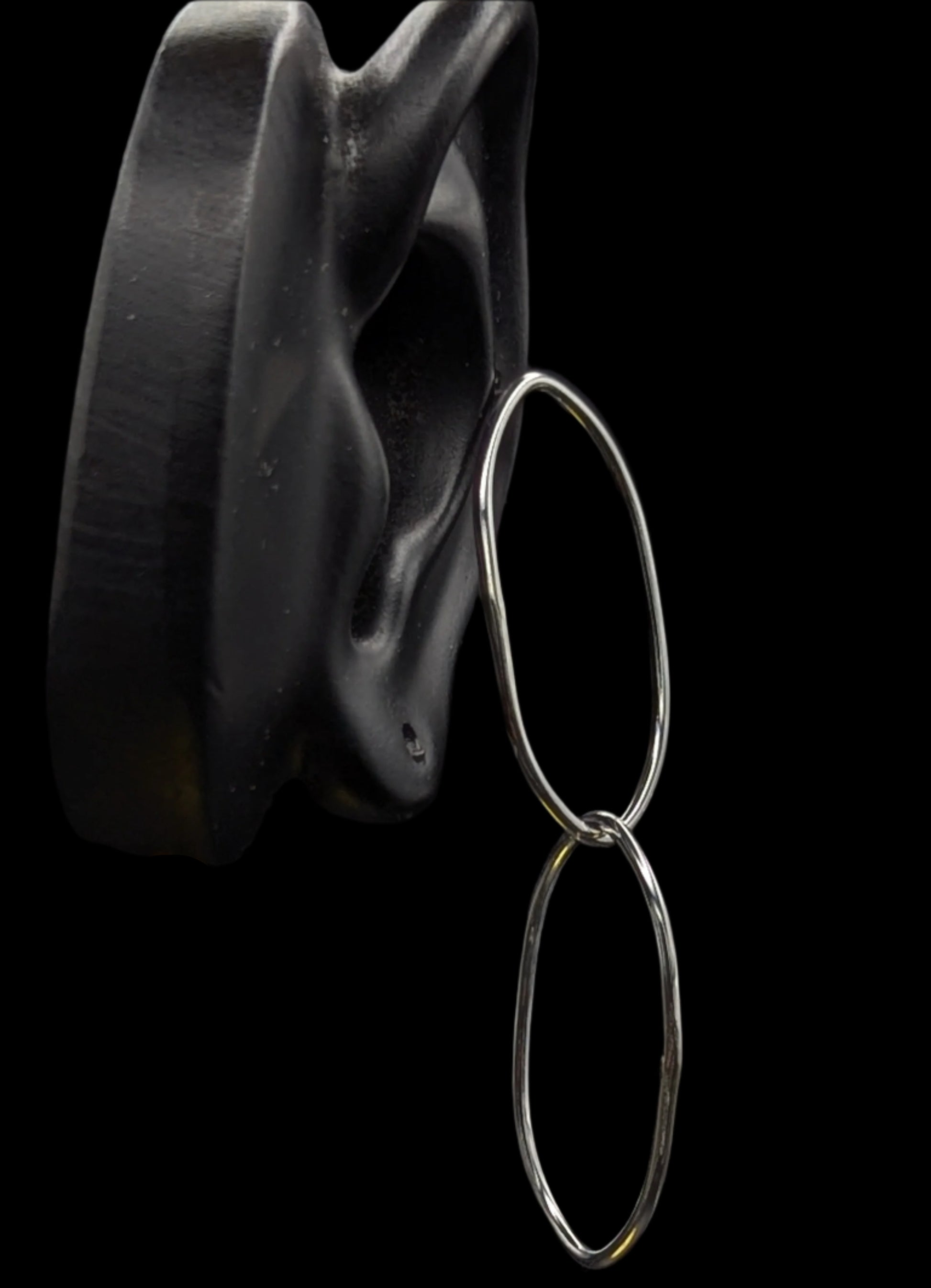 Silver hoop earrings on a black background