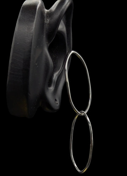 Silver hoop earrings on a black background