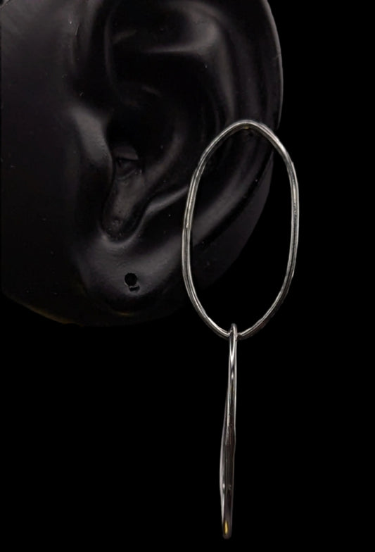 Silver hoop earring with a dangling element on a black background